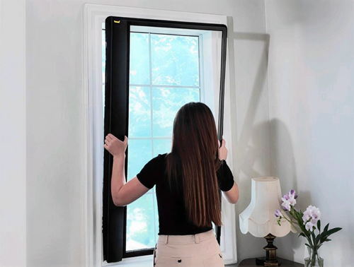 Person pressing the completed blind frame into a window recess